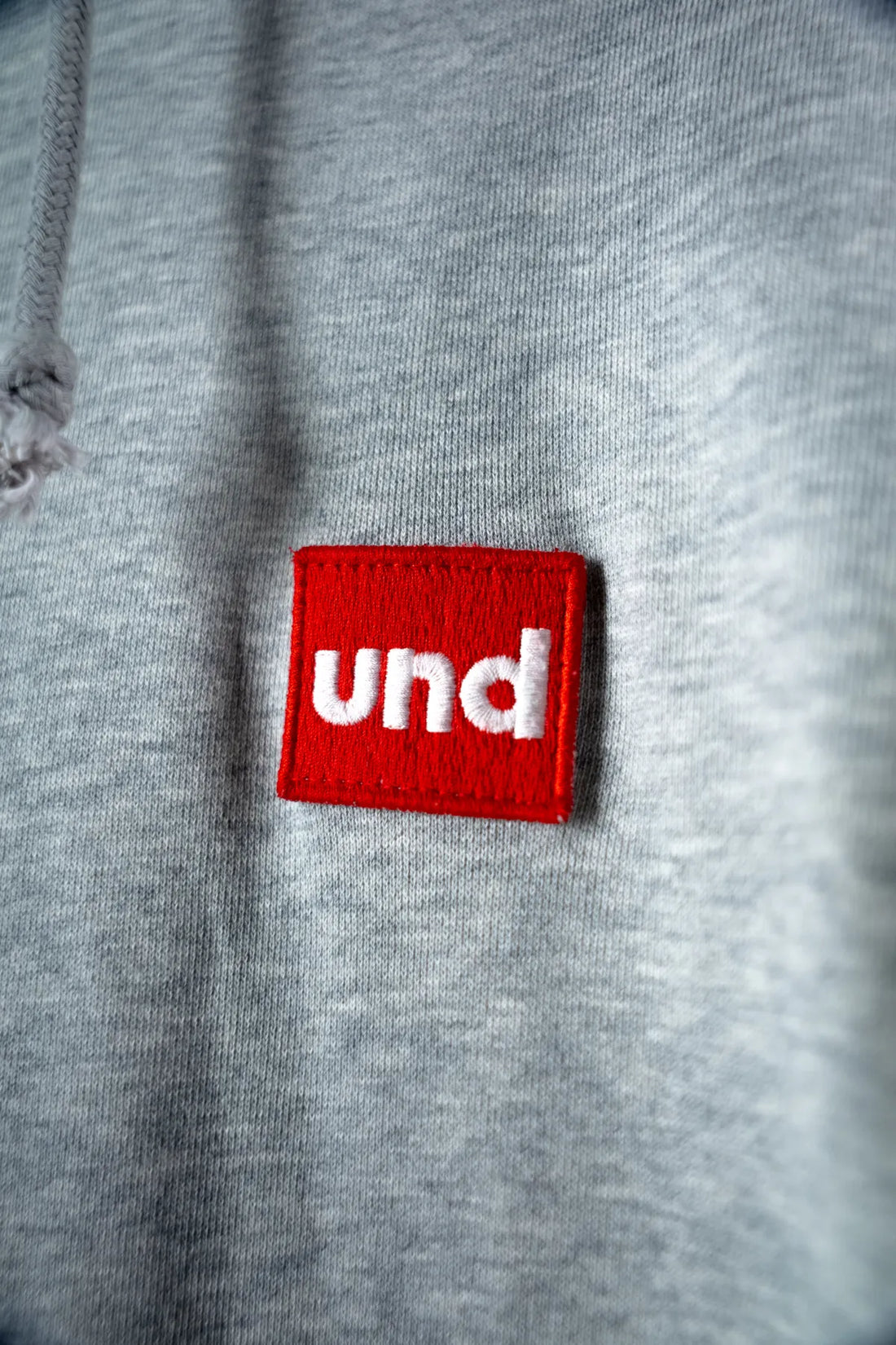 Und grey melange sweat vest with "Red Und Badge"