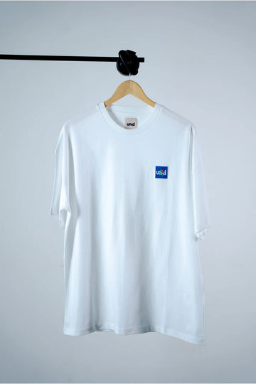 Und white T-shirt with "Und Rose Embroidery in Blue Badge"